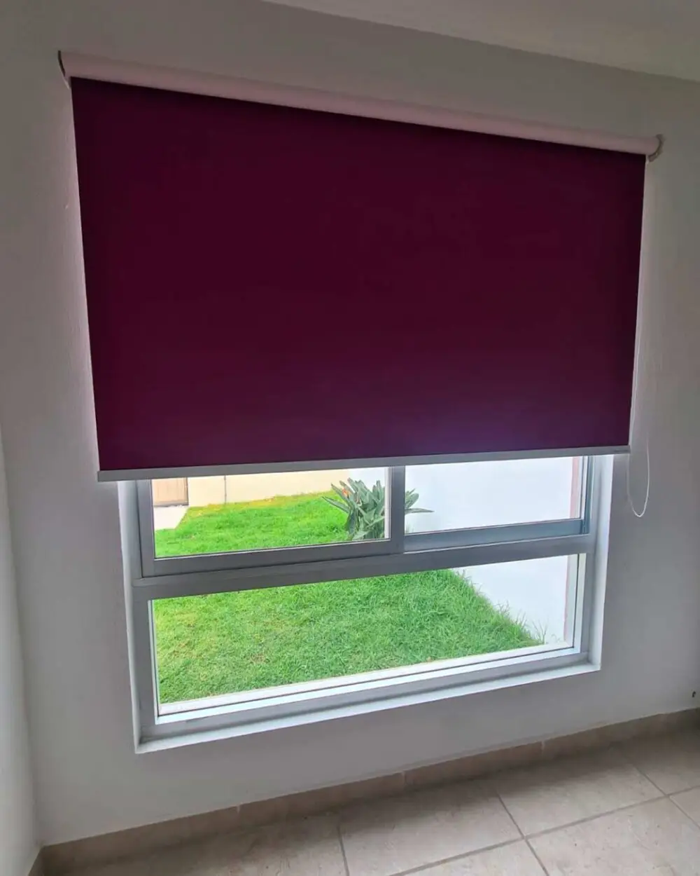 Persiana enrollable blackout entreabierta con control de luz