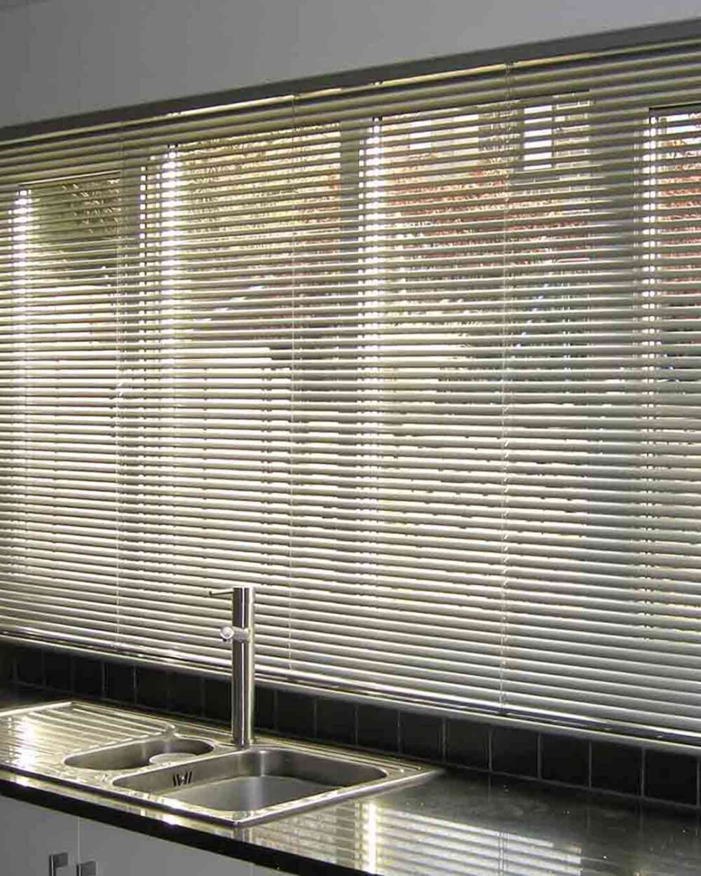 Persiana horizontal de aluminio instalada en cocina con entrada de luz controlada
