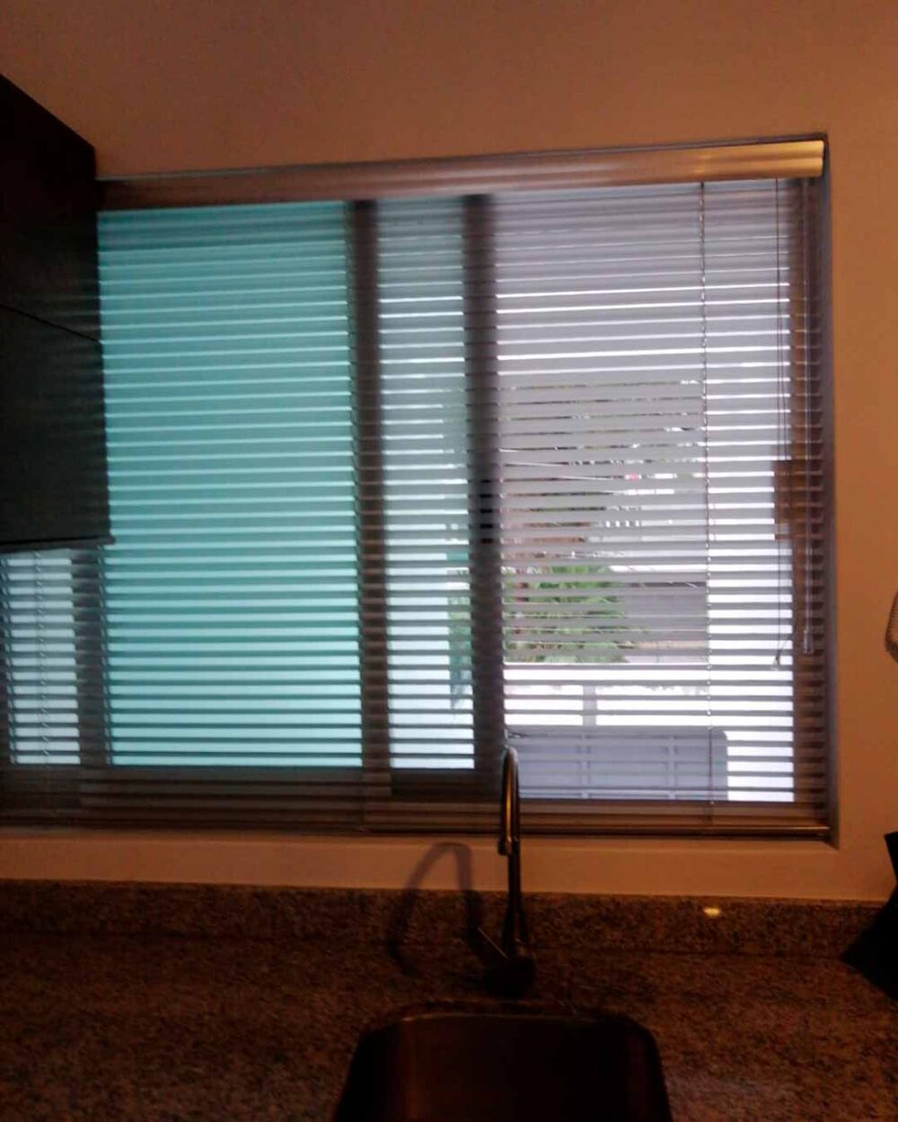Persiana horizontal de aluminio instalada sobre fregadero en cocina funcional