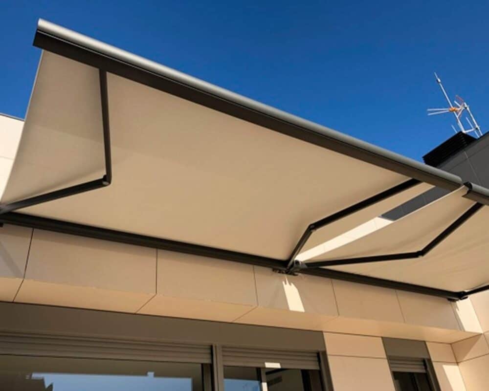 Vista lateral de toldo retráctil con sistema de brazos metálicos