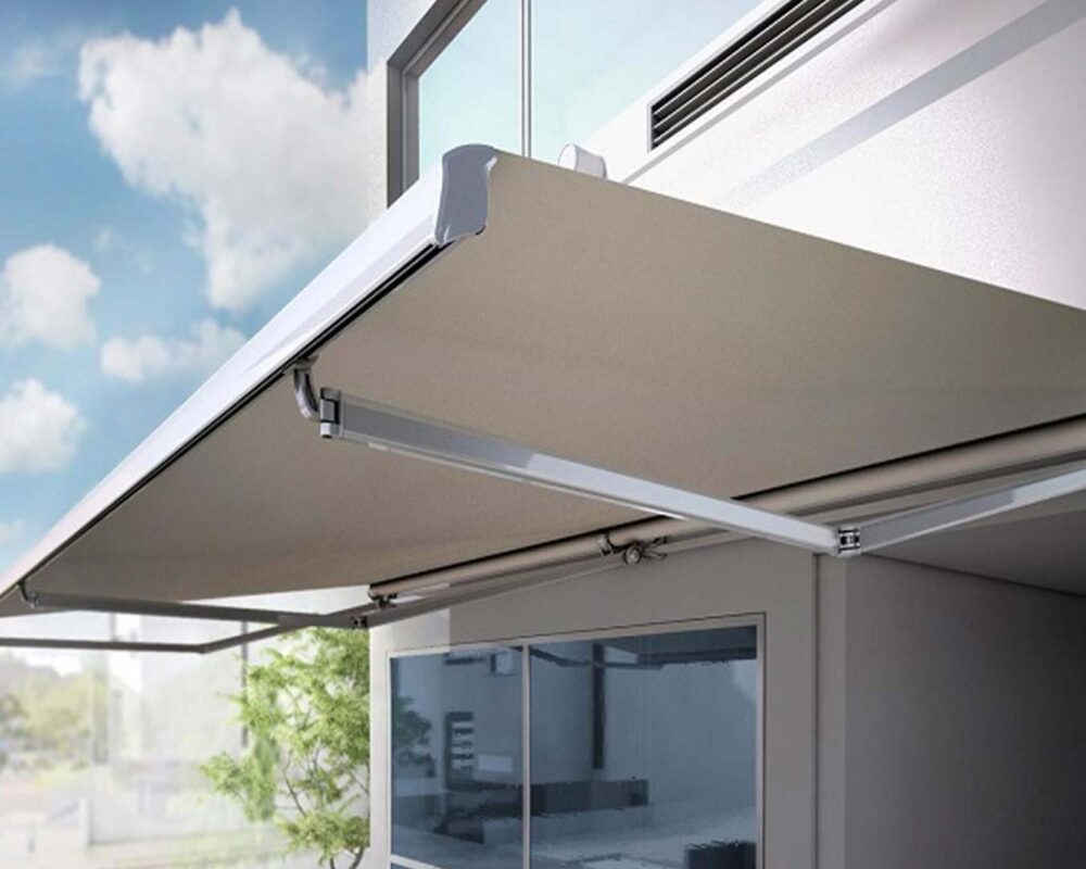 Toldo retráctil extendido sobre fachada de vivienda