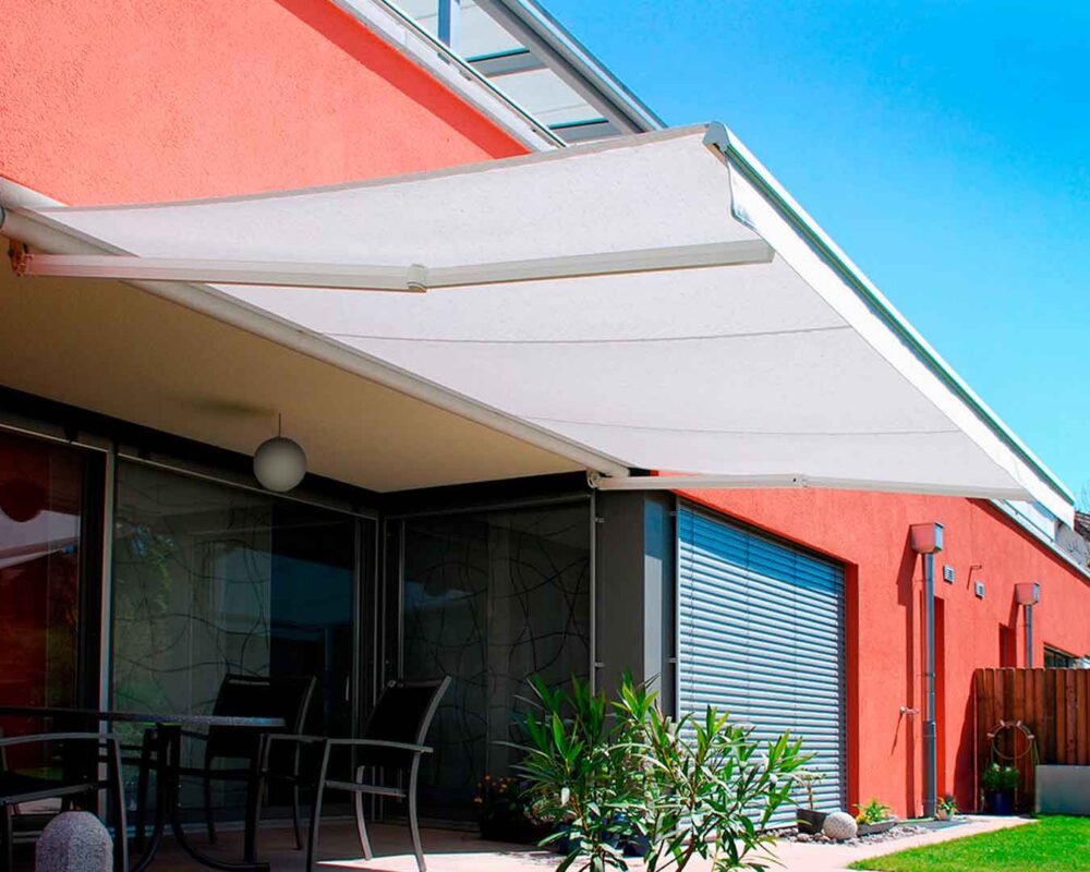 Toldo retráctil montado sobre estructura exterior moderna