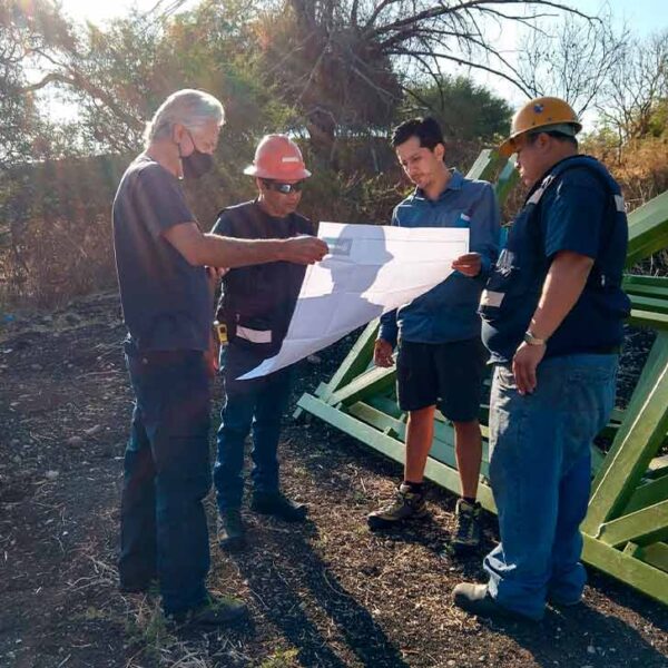 El equipo de NENENKI revisando los planos de ingeniería durante la fase de planeación del proyecto de construcción de torre de escalada.