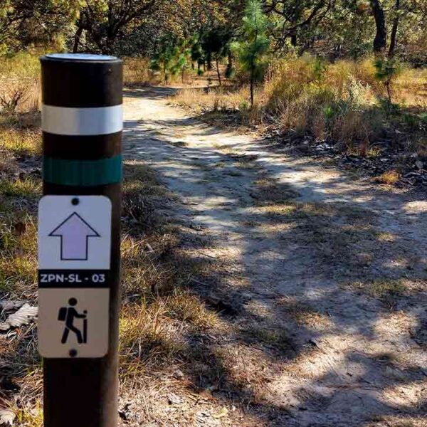 Poste de señalización indicando la ruta del Circuito del Lince, implementado por NENENKI.