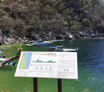 Panel informativo del sendero Boca de Tomatlán–Quimixto con vista al mar en Jalisco.