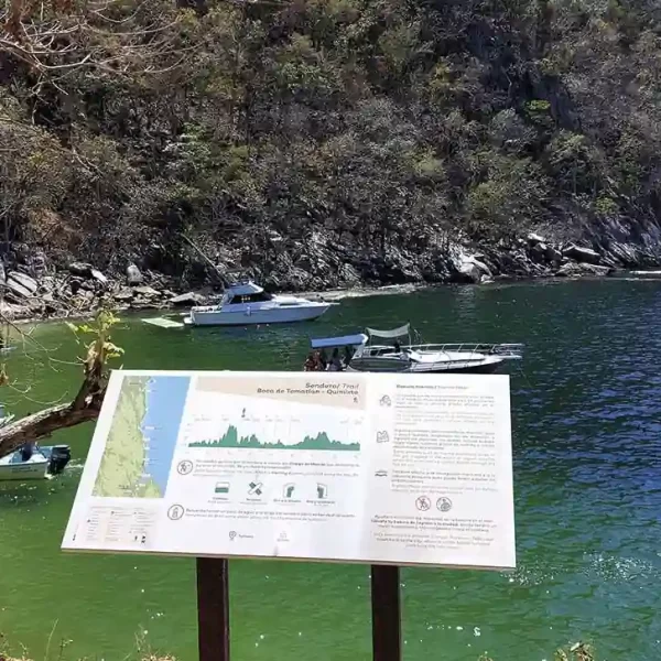 Panel informativo del sendero Boca de Tomatlán–Quimixto con vista al mar en Jalisco.